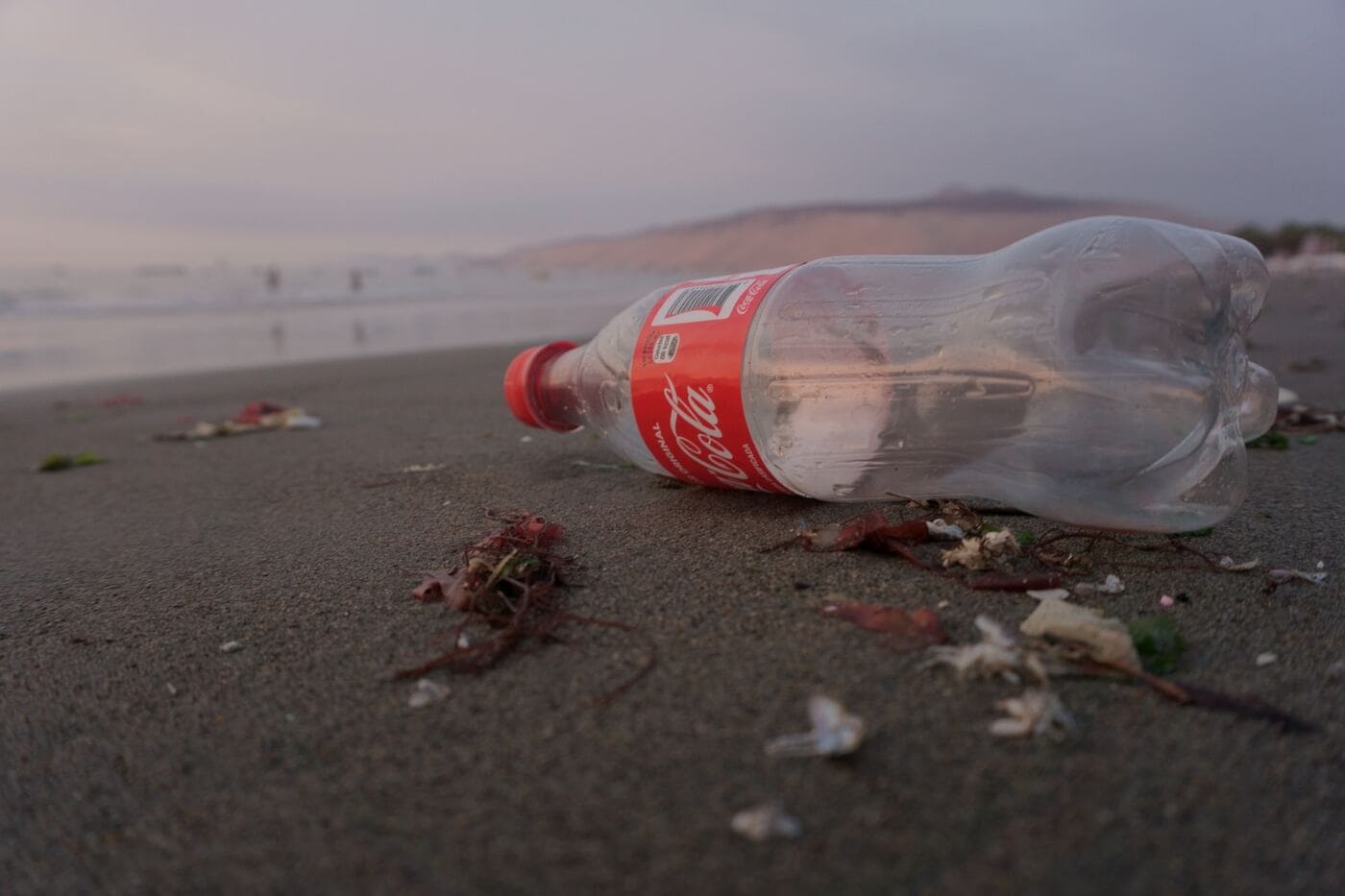 Coca Cola-Plastikflasche am Strand angespült